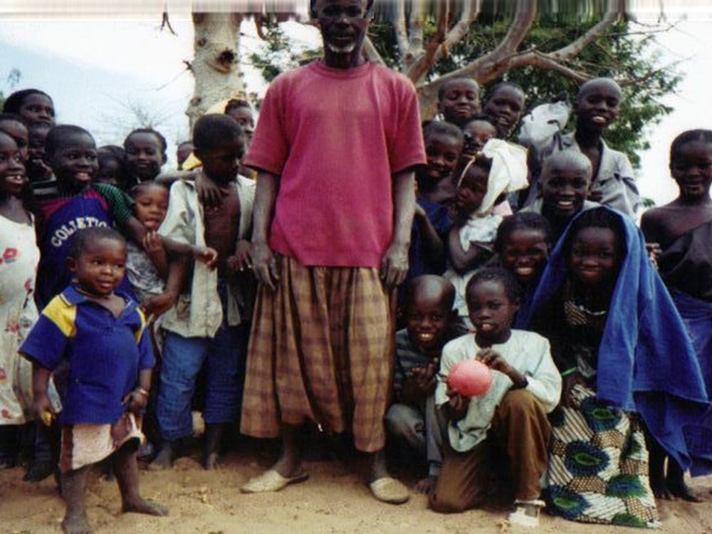 Children and a community member in a village in Senegal